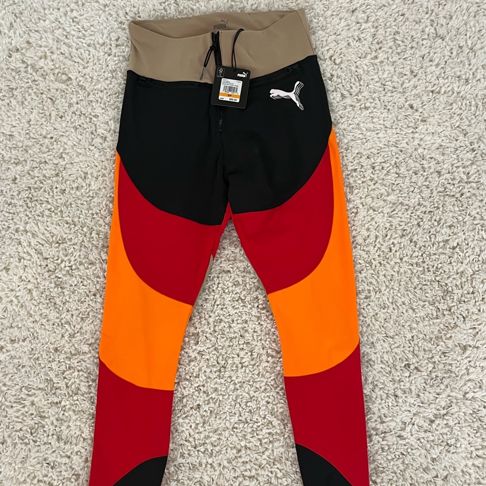 Puma size small leggings are cream black orange and red.